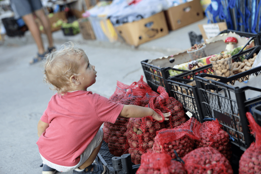 małe dziecko dotyka produktów na targu