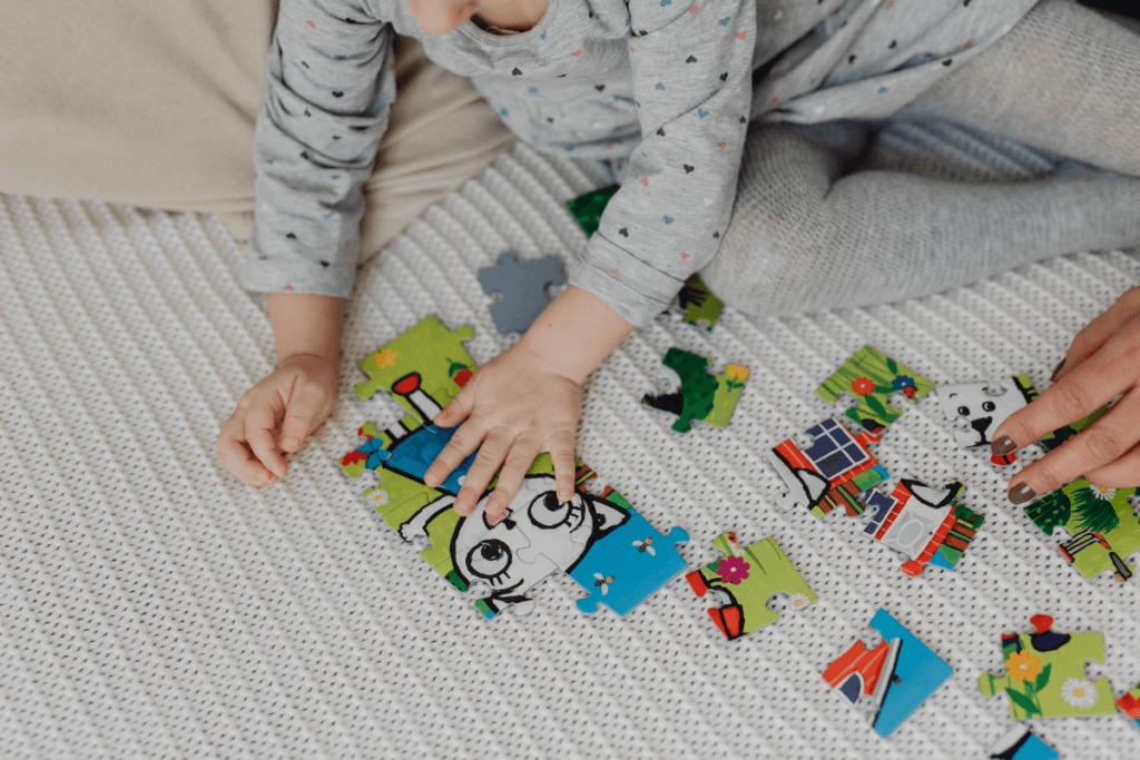 dziecko układa puzzle z mamą